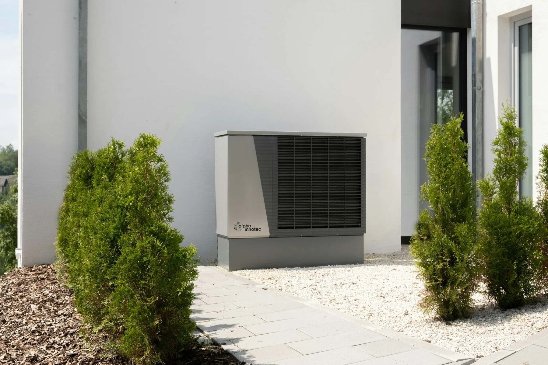 Outdoor heat pump system beside a modern residential building