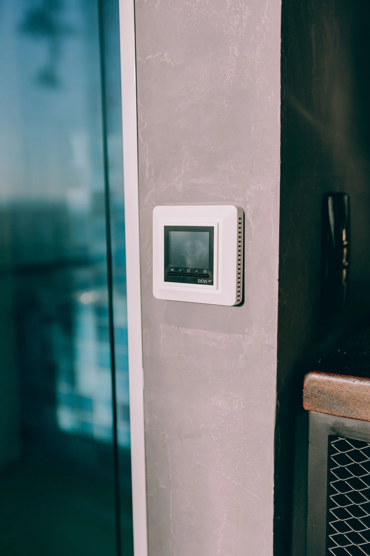 Modern digital thermostat mounted inside a home